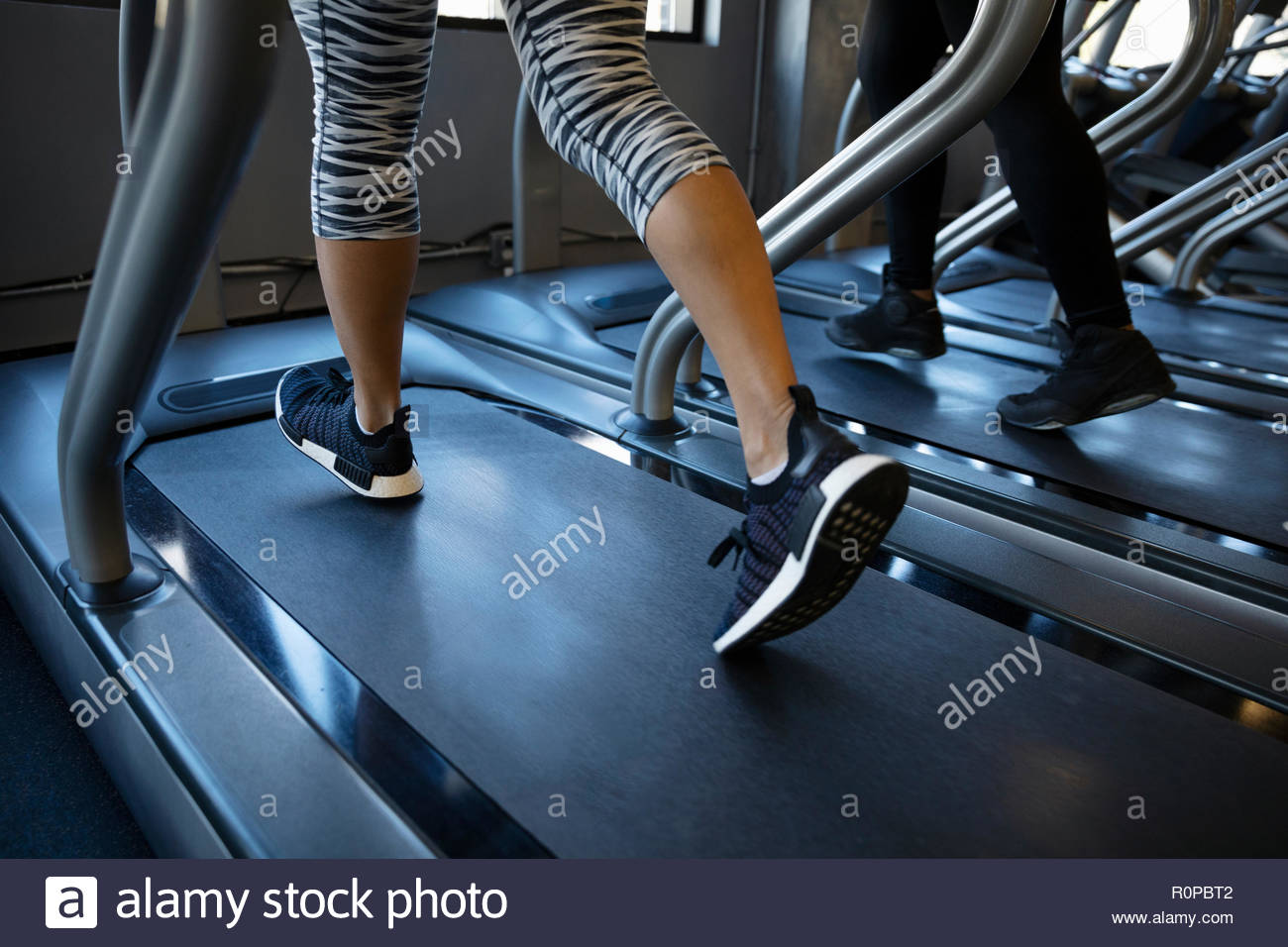 Legs of woman walking on treadmill in gym Stock Photo