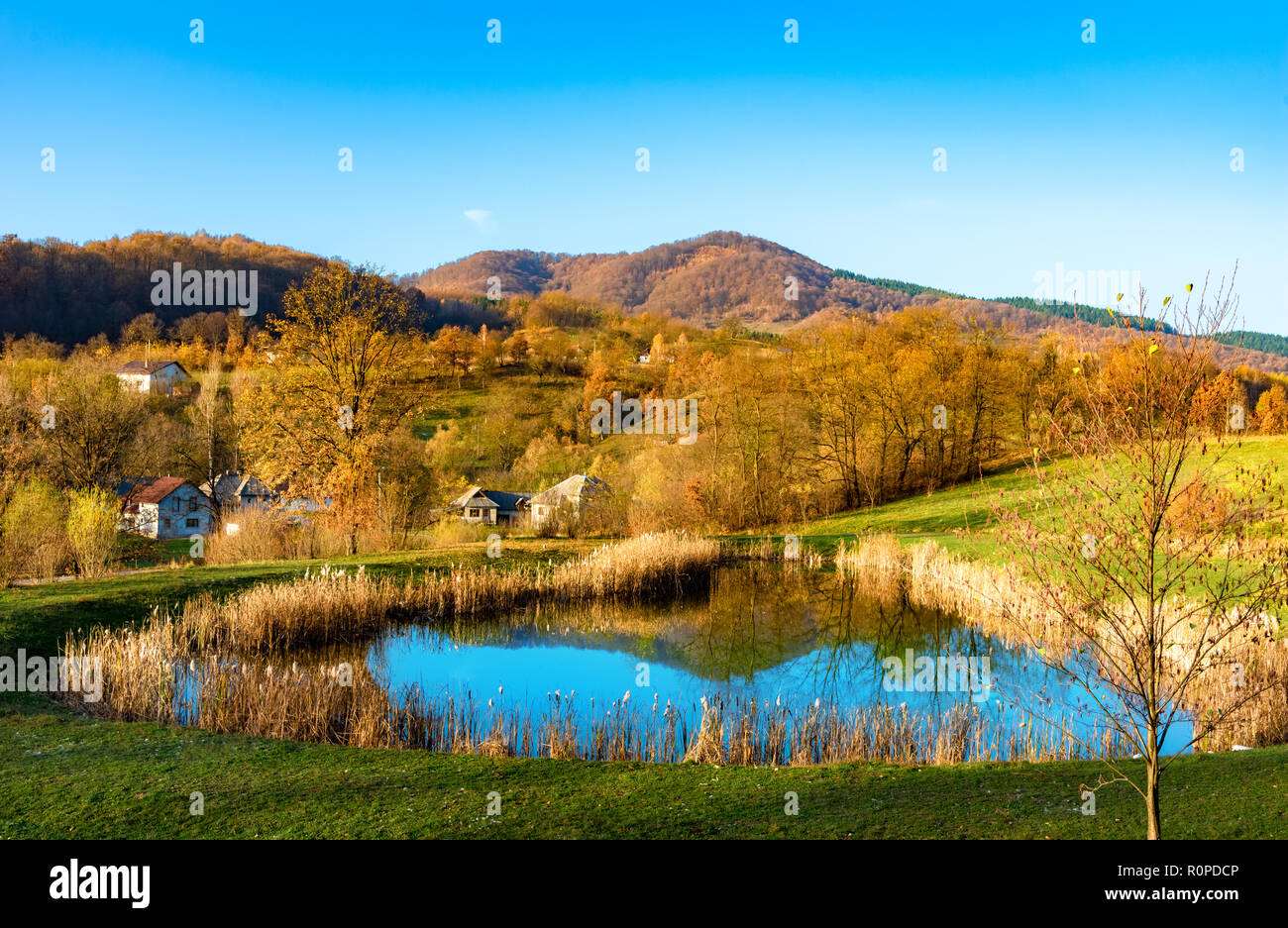 Beautiful autumn landscape with traditional houses and a lake in Sighetu Marmatiei, Maramures region - Romania Stock Photo