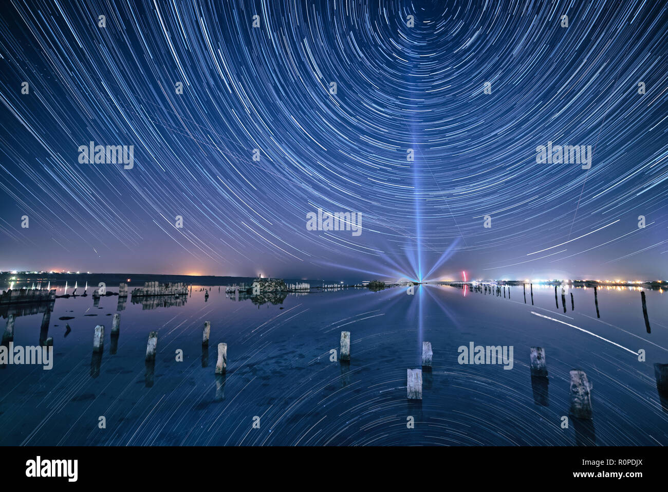 Lake at night with amazing starry sky and star tracks with reflections ...
