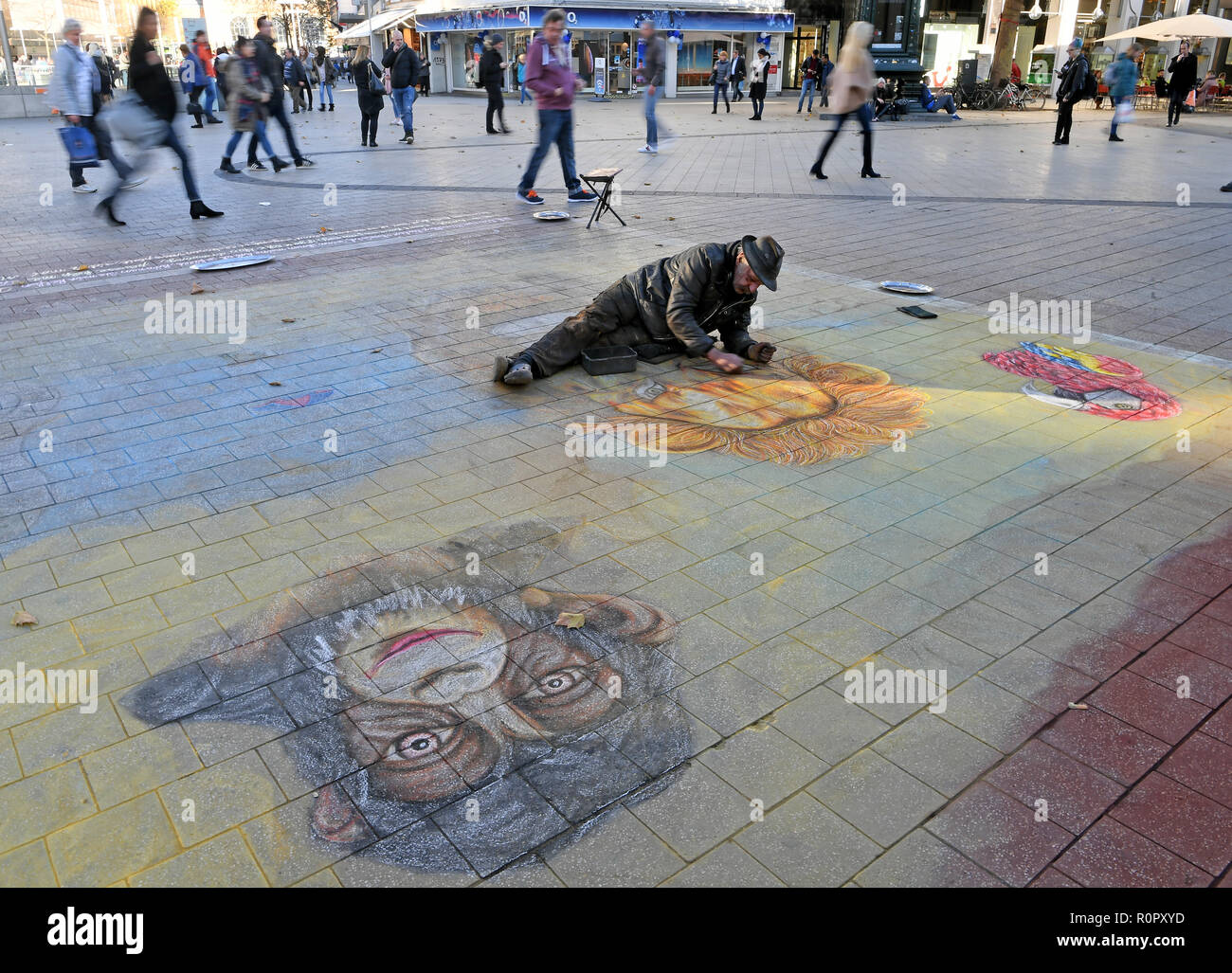 Hannover, Germany. 07th Nov, 2018. The street artist Helmut Artiste paints large paintings lying in the city centre of the capital of Lower Saxony. The thermometer in parts of Lower Saxony is to rise to just under 20 degrees Celsius on this warm autumn day. Credit: Holger Hollemann/dpa/Alamy Live News Stock Photo