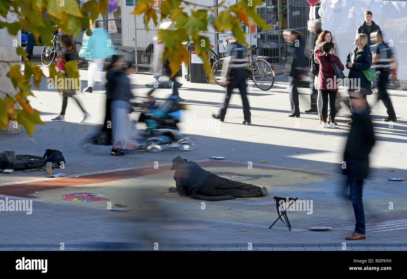 Hannover, Germany. 07th Nov, 2018. The street artist Helmut Artiste paints large paintings lying in the city centre of the capital of Lower Saxony. The thermometer in parts of Lower Saxony is to rise to just under 20 degrees Celsius on this warm autumn day. Credit: Holger Hollemann/dpa/Alamy Live News Stock Photo