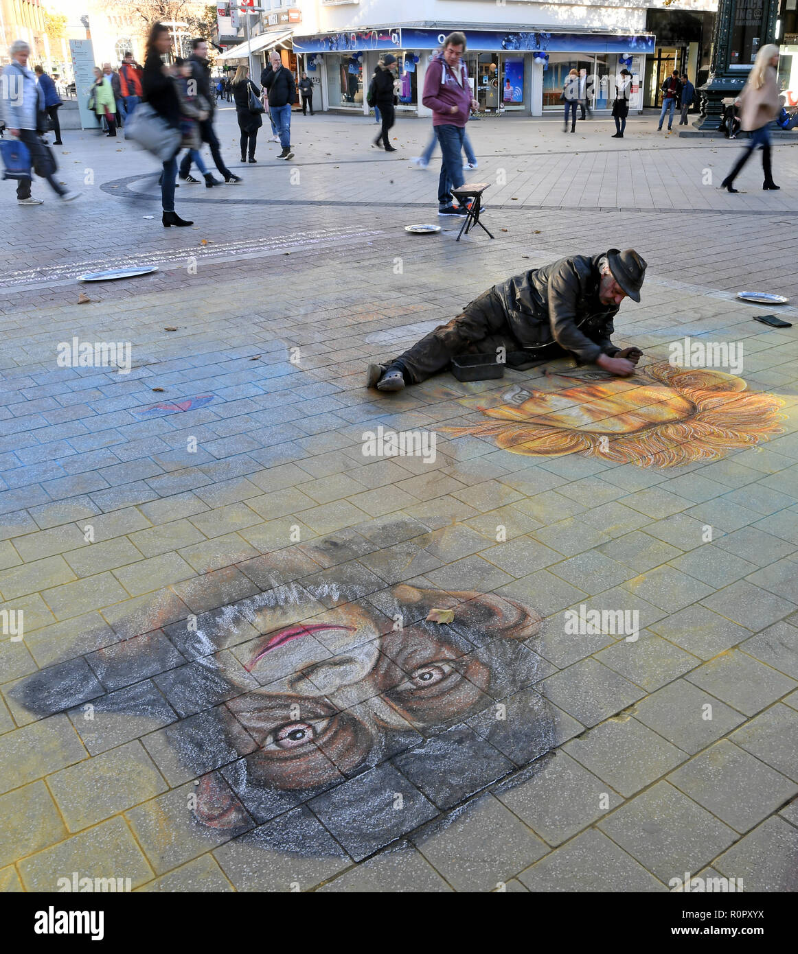 Hannover, Germany. 07th Nov, 2018. The street artist Helmut Artiste paints large paintings lying in the city centre of the capital of Lower Saxony. The thermometer in parts of Lower Saxony is to rise to just under 20 degrees Celsius on this warm autumn day. Credit: Holger Hollemann/dpa/Alamy Live News Stock Photo