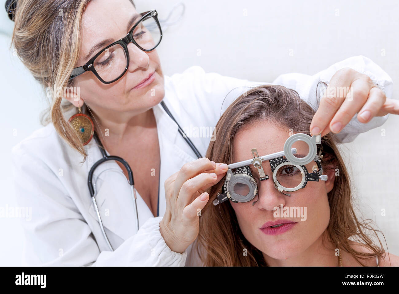 specialist in ophthalmology test new lenses on a patient with phoropter Stock Photo