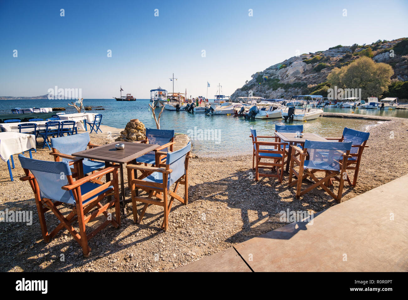 Tables and chairs near harbor in Kolymbia (Rhodes, Greece) Stock Photo