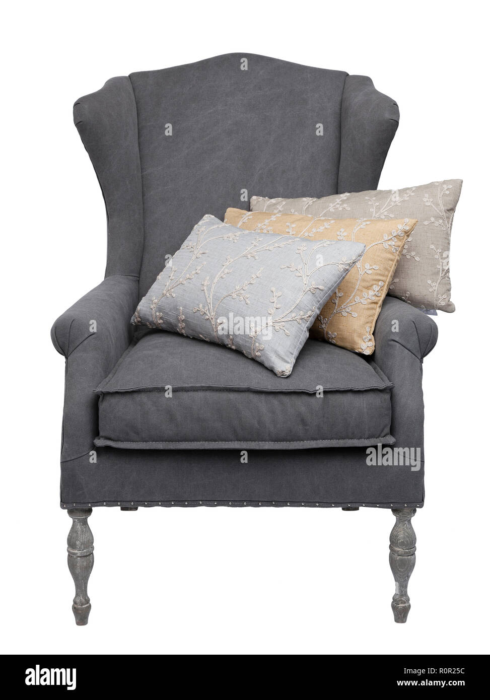Traditional grey arm chair with 3 floral cushions, isolated on a white background. Stock Photo
