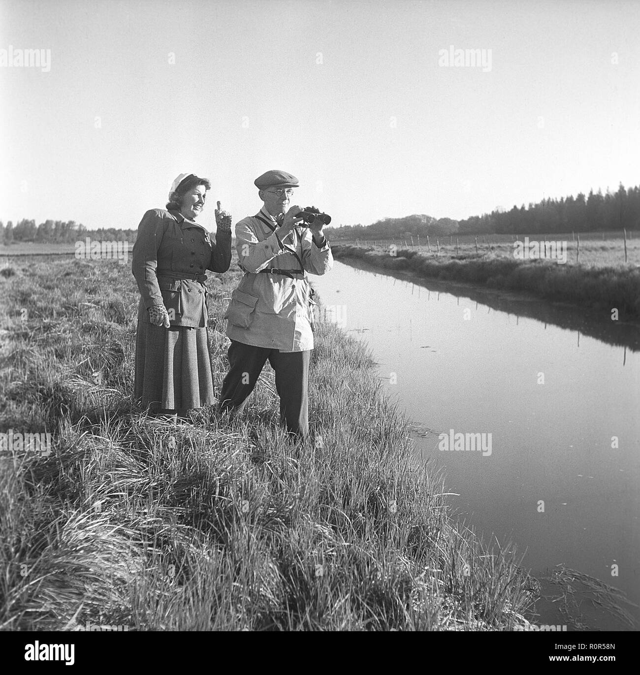sprede Indføre latin 1940s outdoor life. A couple is out in the nature and is interested in  plants and flowers. They are wearing the typical 1940s kind of outdoor  clothes of sport character that is