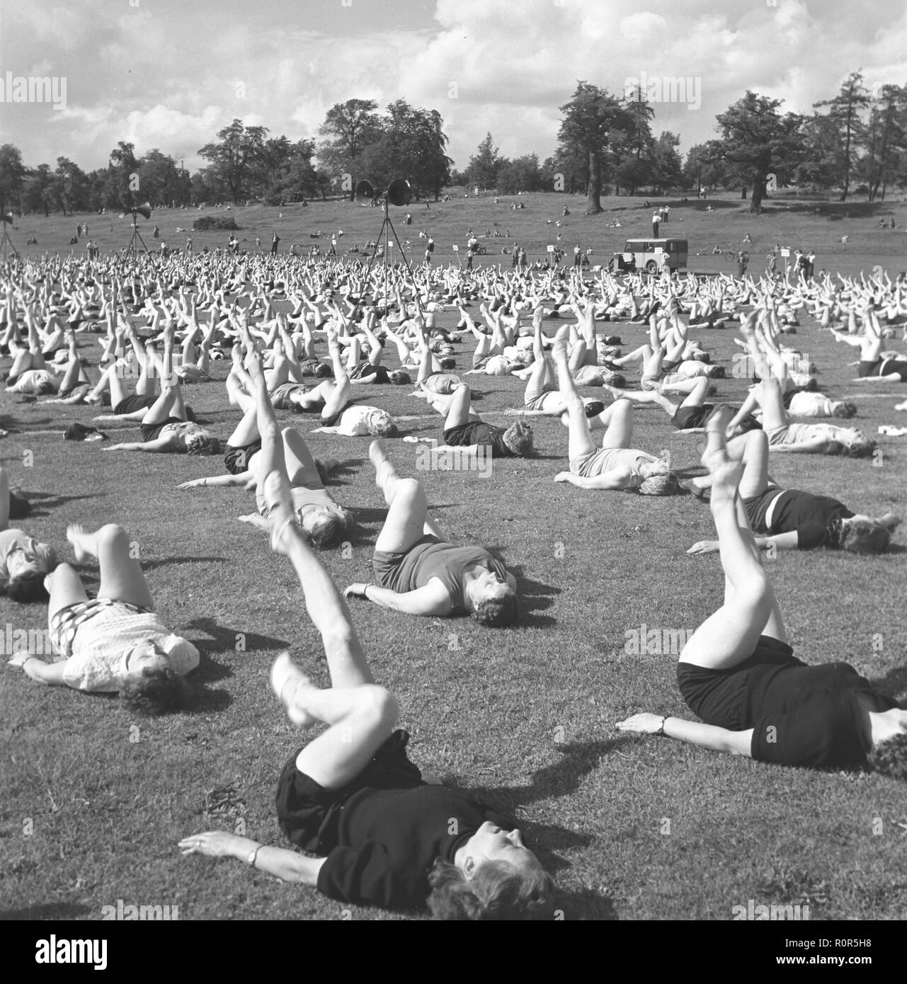Gymnastics in the 1950s. The popular womens housewife gymnastics is being practiced everywhere. Here a large number of women are exercising together outdoors. Sweden 1954 Stock Photo