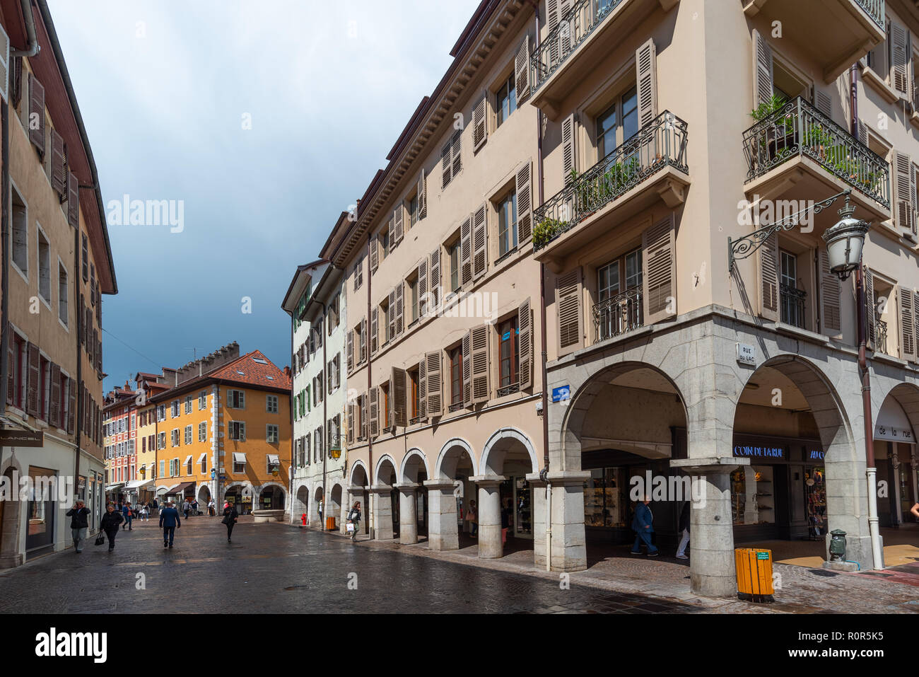 Street view of the beautiful town of Annecy in France showing a medieval urban fabric with arched shopping on the ground floors. Stock Photo