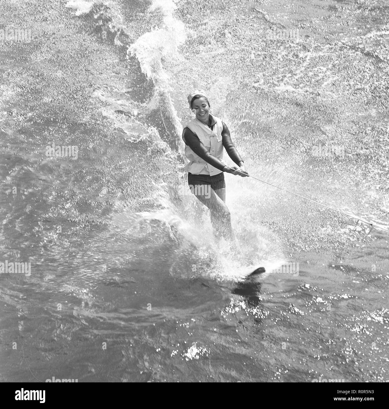 Waterskiing in the 1960s. A young woman is waterskiing. Sweden July 1964 Stock Photo