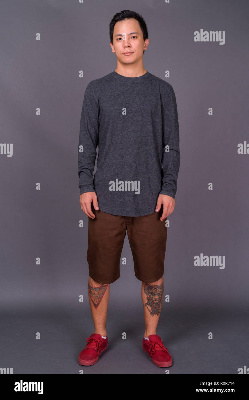 Portrait of young handsome man against gray background Stock Photo