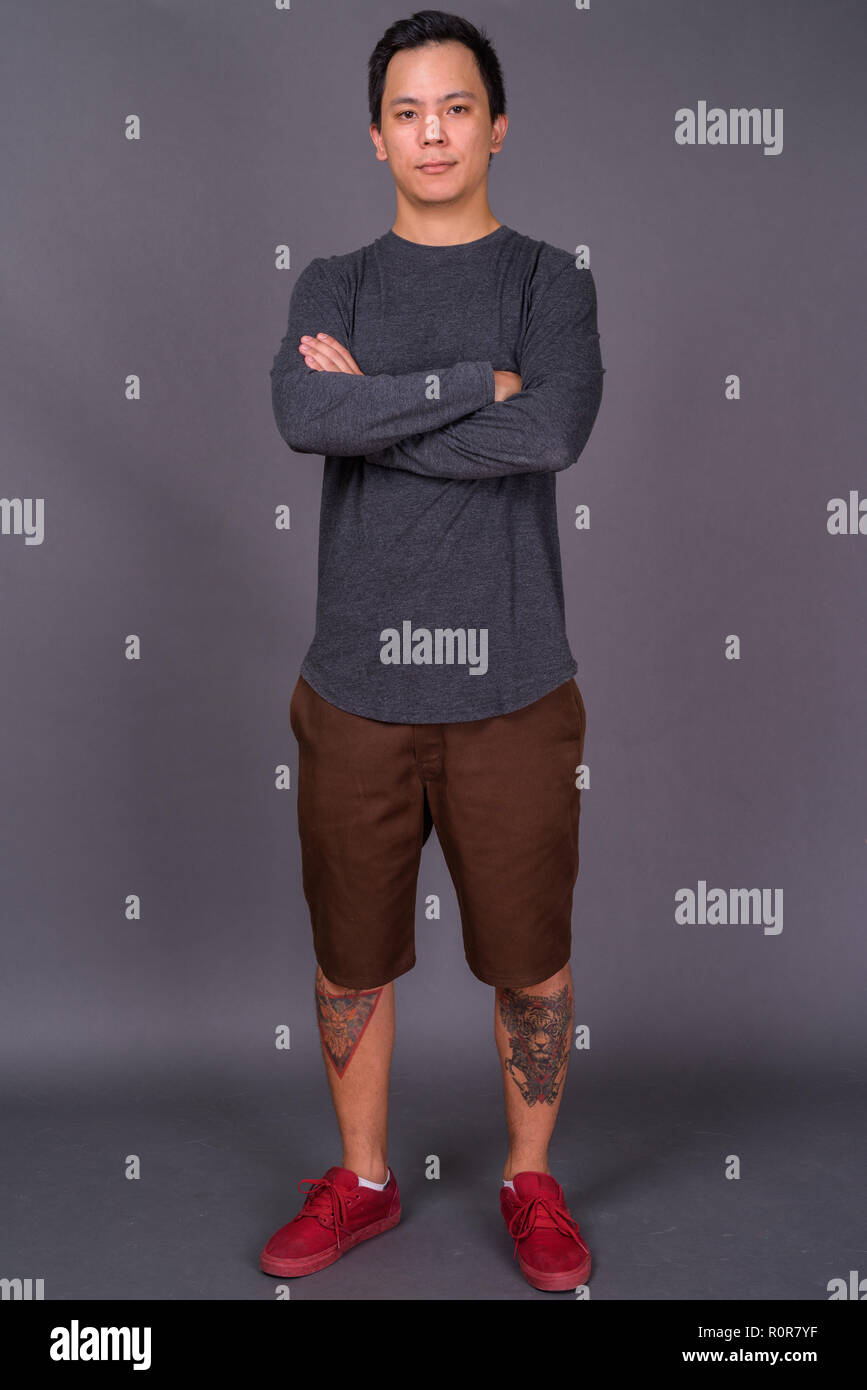 Portrait of young handsome man against gray background Stock Photo