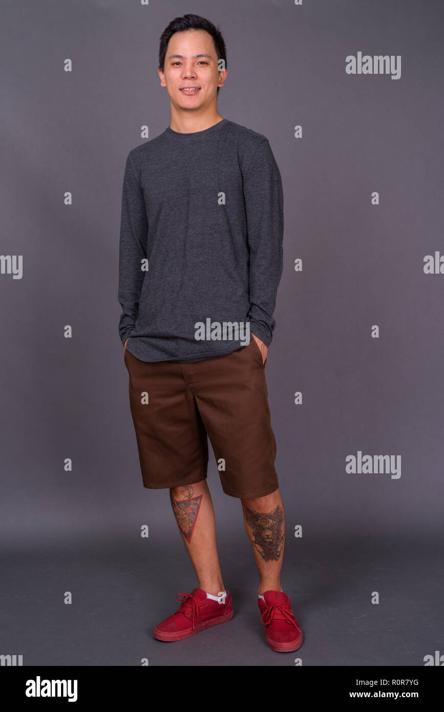 Portrait of young handsome man against gray background Stock Photo