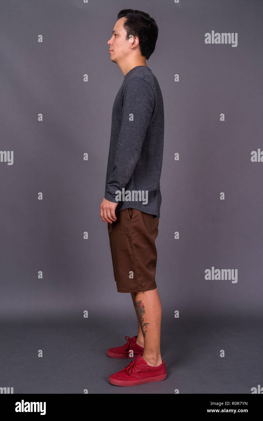 Portrait of young handsome man against gray background Stock Photo