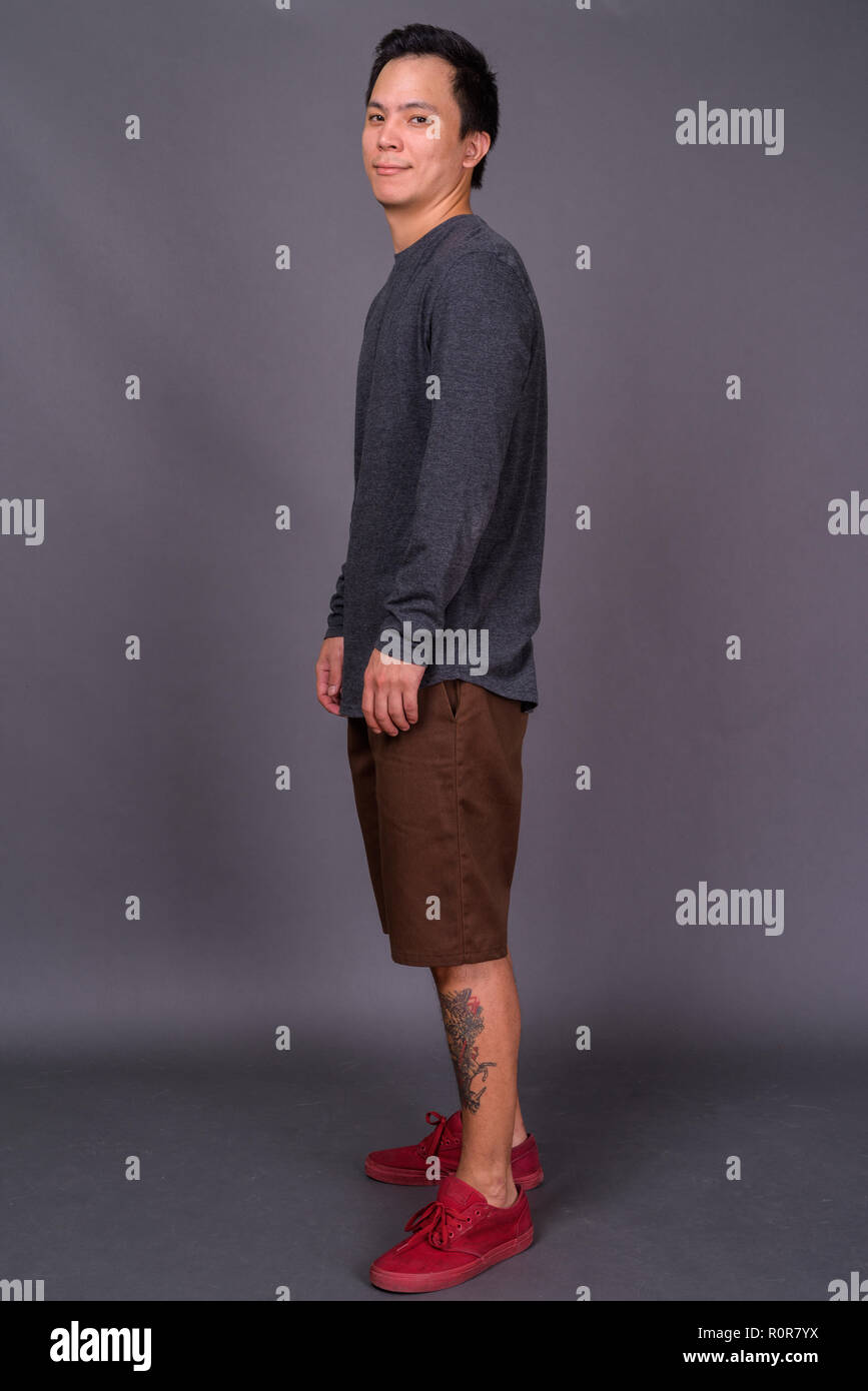 Portrait of young handsome man against gray background Stock Photo