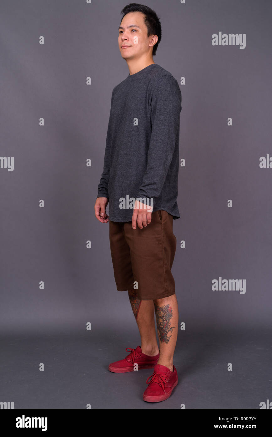 Portrait of young handsome man against gray background Stock Photo