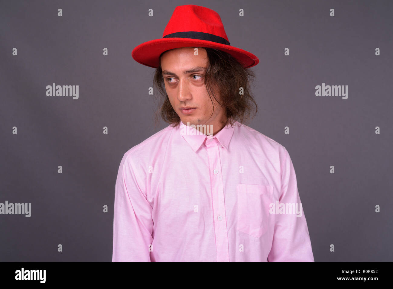 Portrait of young handsome man against gray background Stock Photo - Alamy