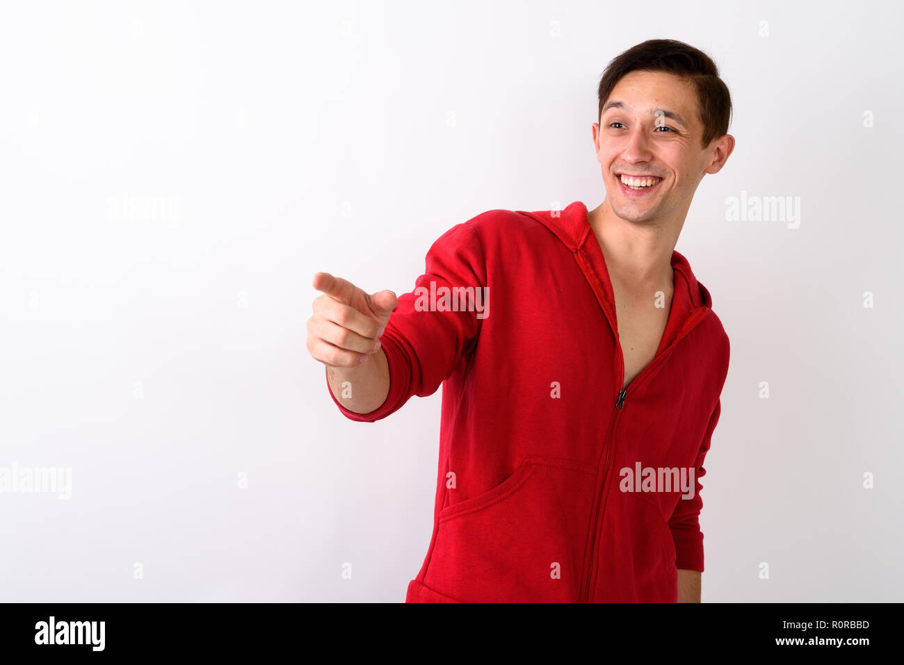 Studio shot of happy young handsome man smiling while pointing t Stock Photo