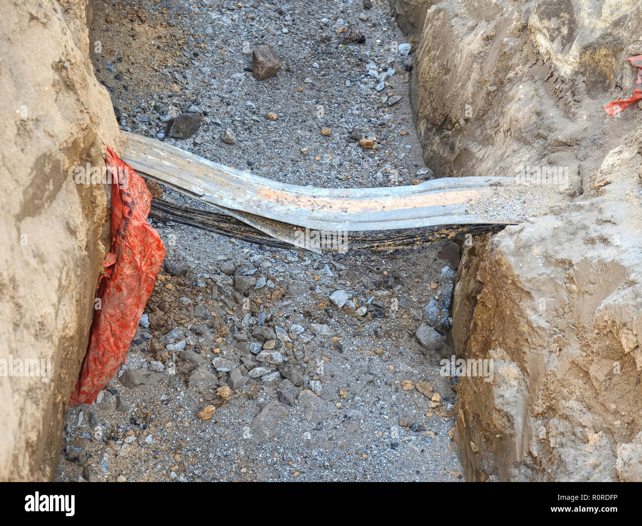 Pipe and cables in trench at road crossing laying pipelines. Building