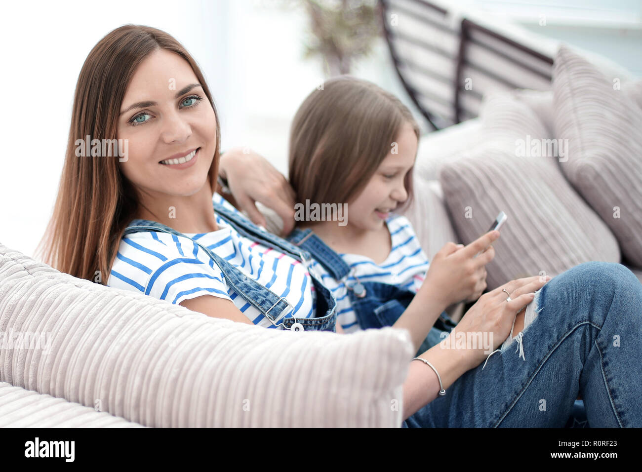 mother and daughter sitting on a comfortable sofa Stock Photo Alamy