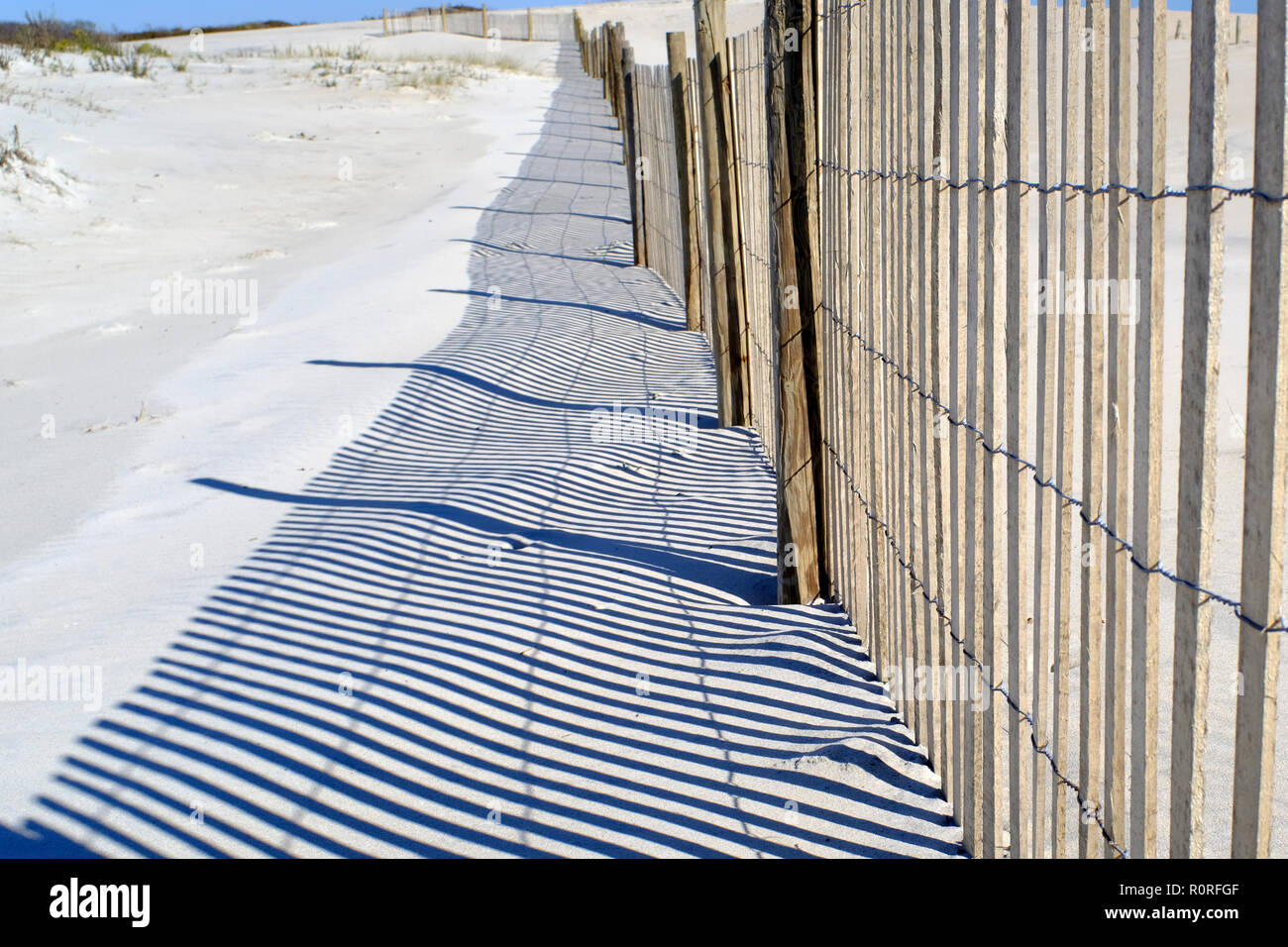 Storm fence and shadows on dunes on Assateague National Seashore Park in Maryland Stock Photo