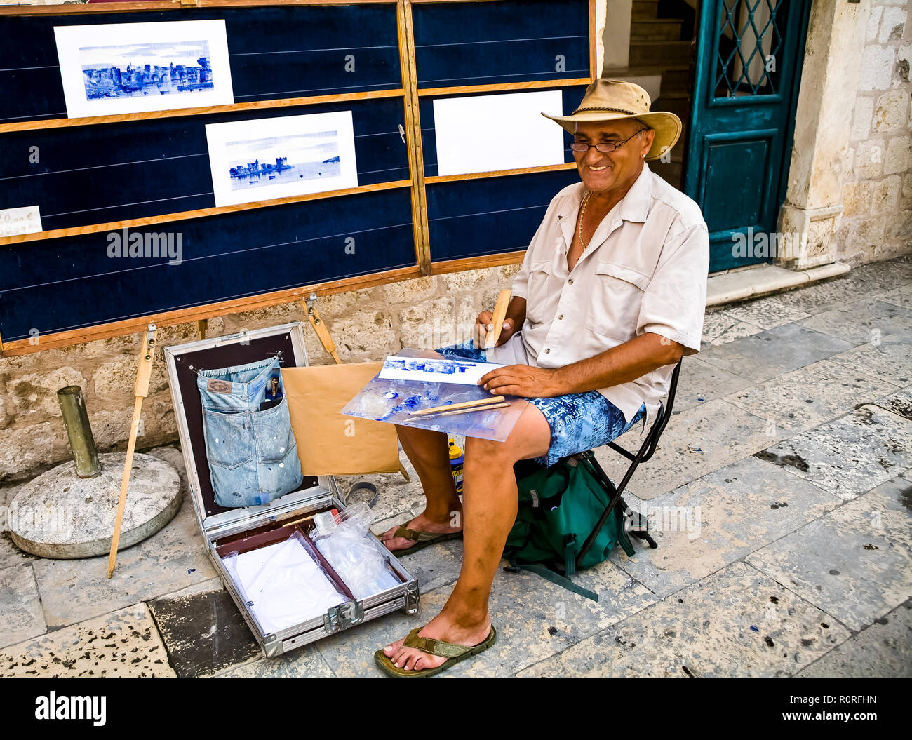 Artist sitting outside Walls of the Old City of Dubrovnik painting with bamboo sticks.  Selling artwork to tourists.  © Myrleen Pearson  ...Ferguson Cate Stock Photo