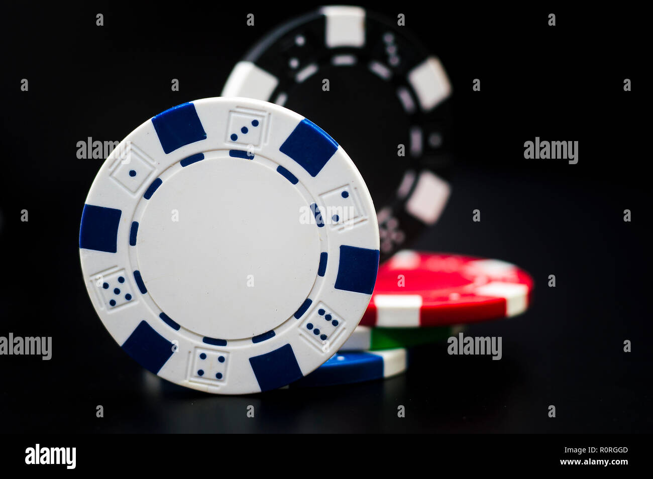 set of poker chips of different colors on a black background Stock