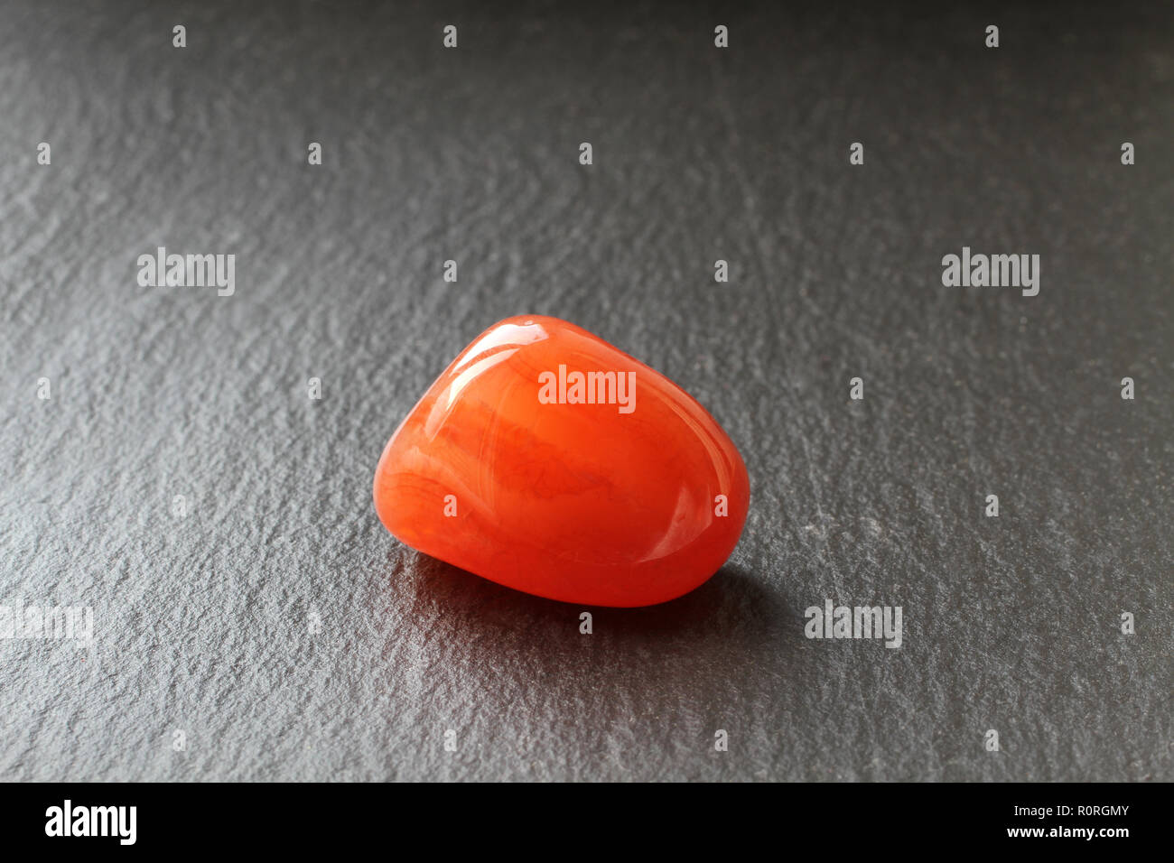 Cornelian stone on a black stone board Stock Photo