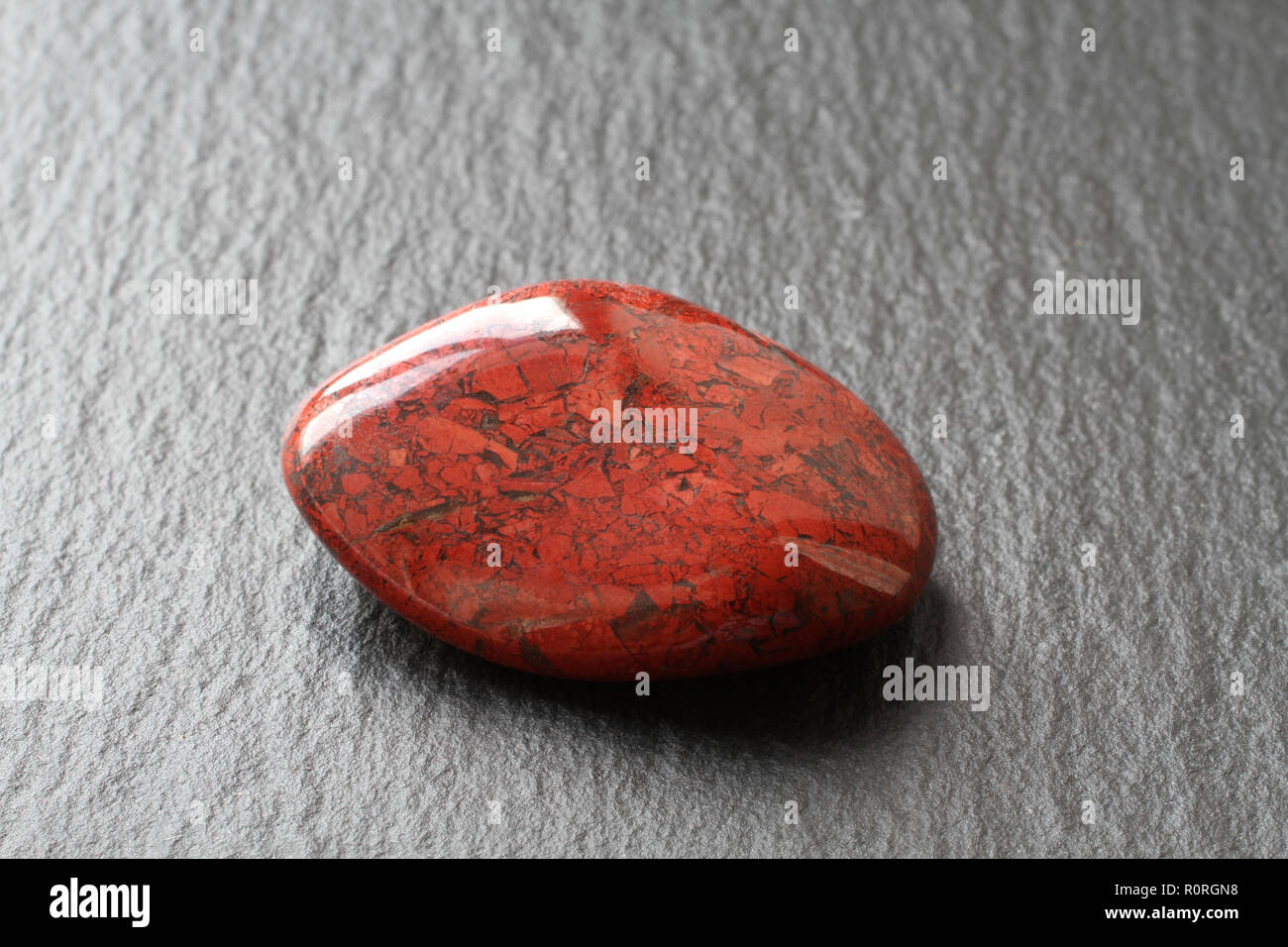 Red jasper stone on a black stone board Stock Photo