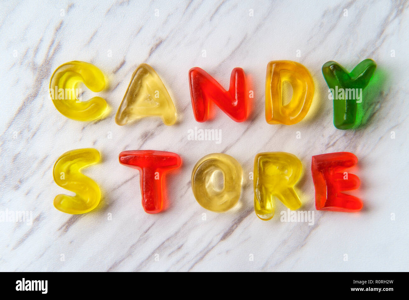 Assorted colorful gummy candy letters spell the words Candy Store Stock