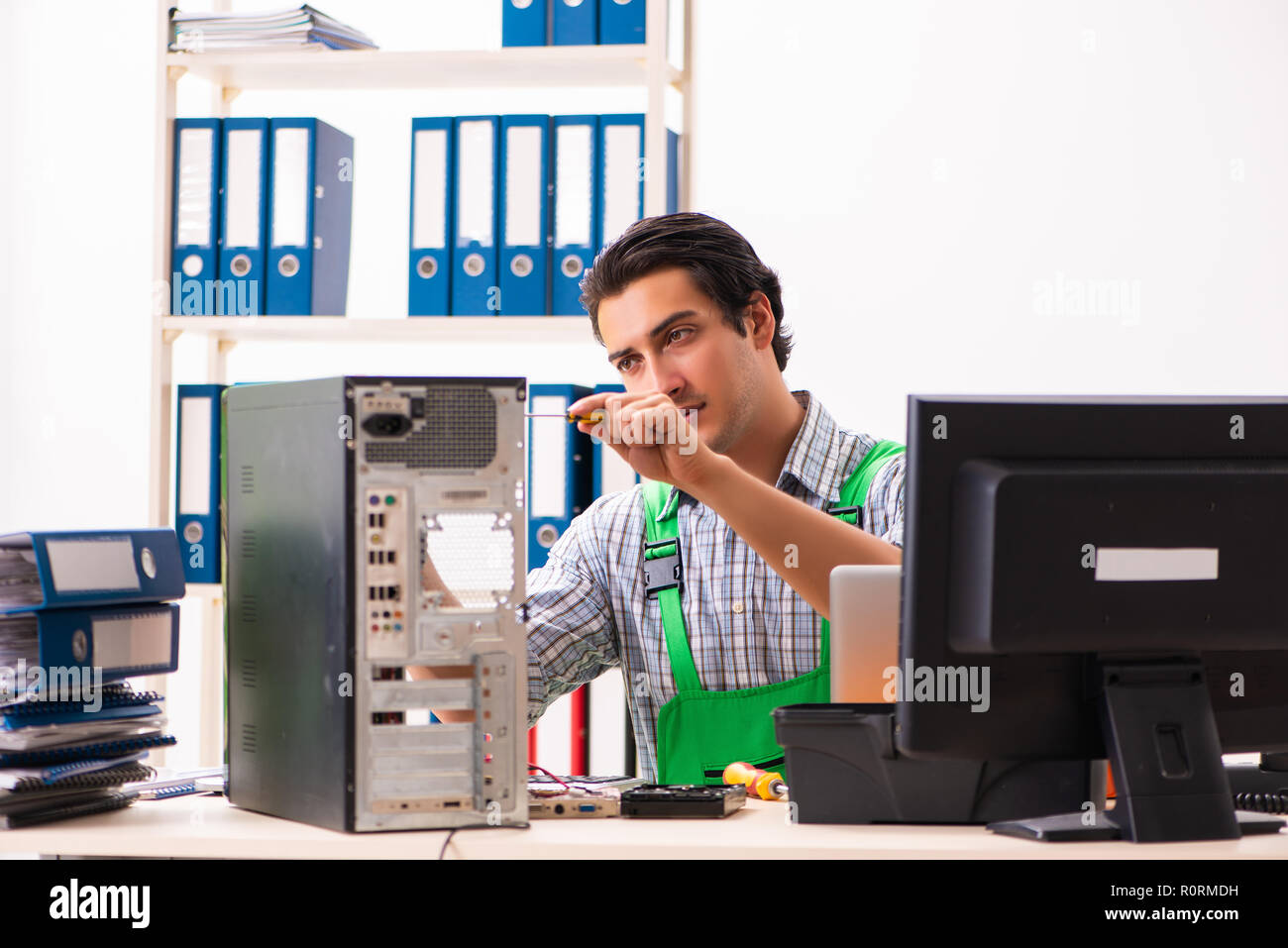 Young engineer repairing broken computer at the office Stock Photo - Alamy