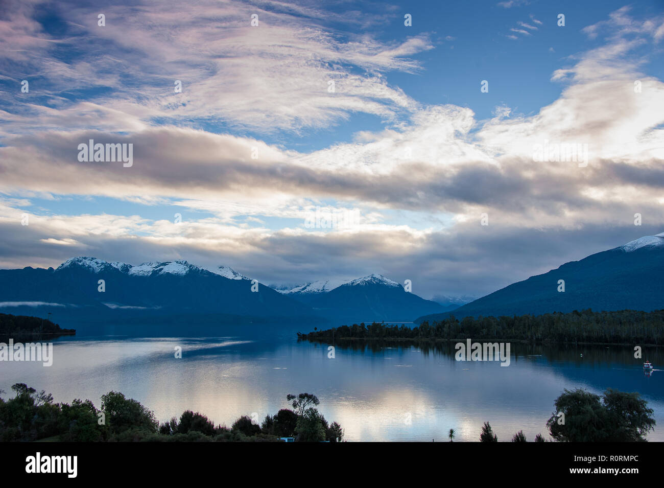 Beautiful view to Lake Te Anau and the Murchison Mountains from Te Anau Downs. Sunset over the lake with pretty pink cloud reflections Stock Photo