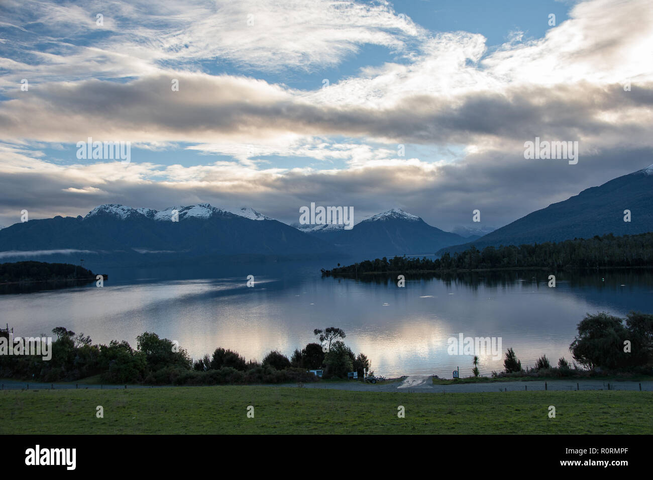 Beautiful view to Lake Te Anau and the Murchison Mountains from Te Anau Downs. Sunset over the lake with pretty pink cloud reflections Stock Photo