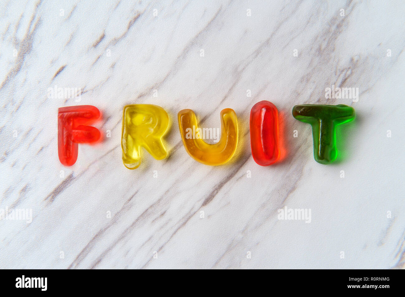 Assorted colorful gummy candy letters spell the word Fruit Stock Photo