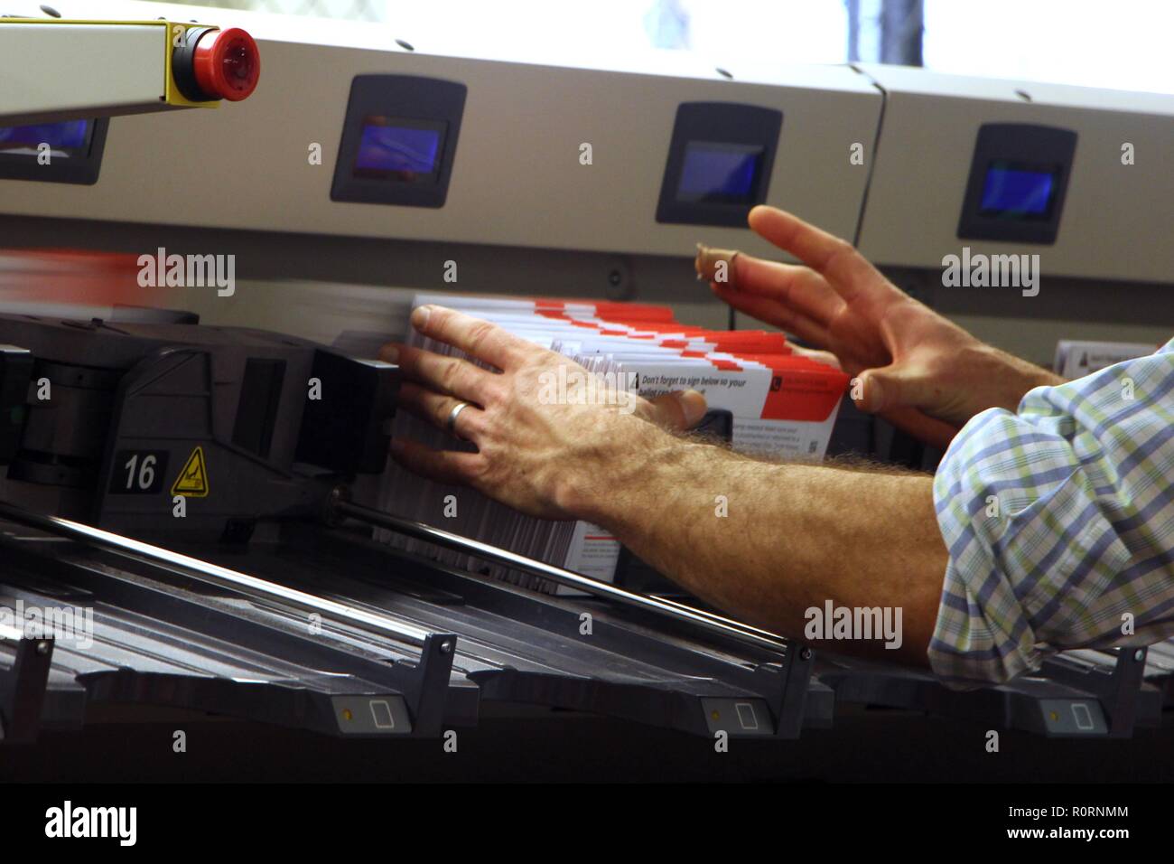 A poll worker seen pulling ballots from a processing machine at the King County Elections headquarters in Renton, Voting in Washington state is done by mail and returned ballots are sorted and registered by machine before being counted. More than US$30 million has been spent on the race between Republican Dino Rossi and Democrat Kim Schrier in Washington's 8th Congressional District, one of the five most expensive contests in the country in 2018. Stock Photo