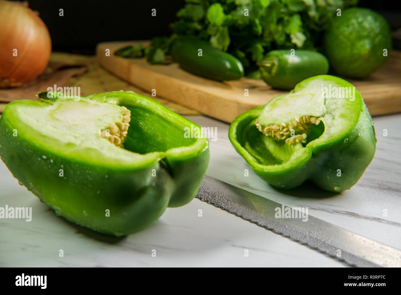 Green bell pepper sliced in half showing seeds and pith Stock Photo Alamy