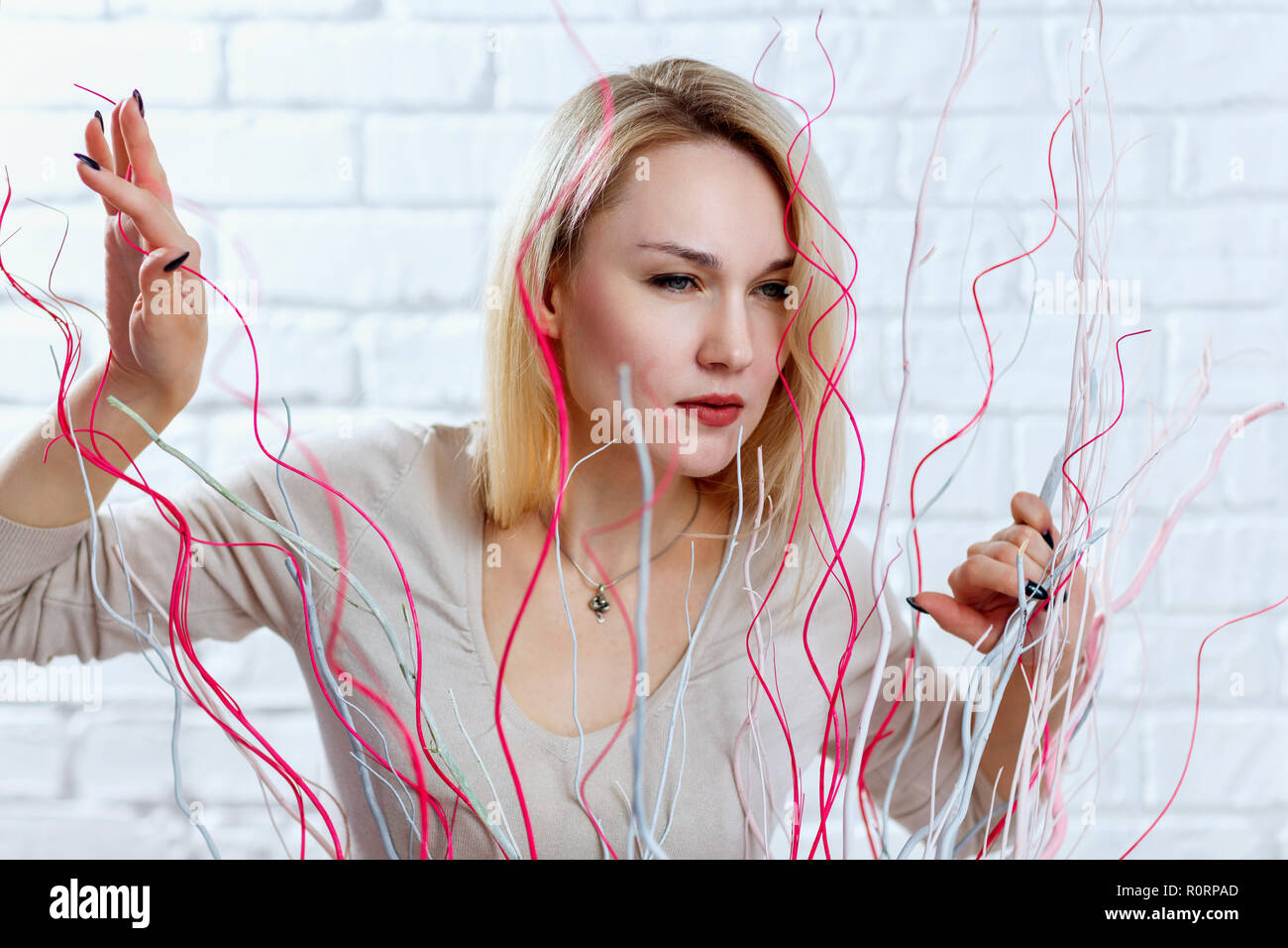 Woman with suspicious sight looking out over decoration in studio. Stock Photo