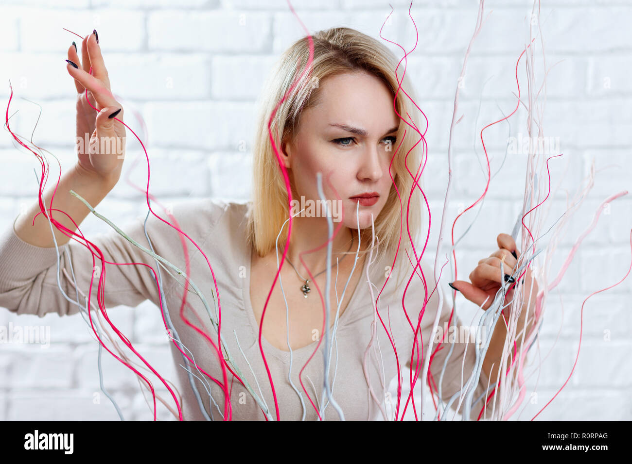 Woman with suspicious sight looking out over decoration in studio. Stock Photo