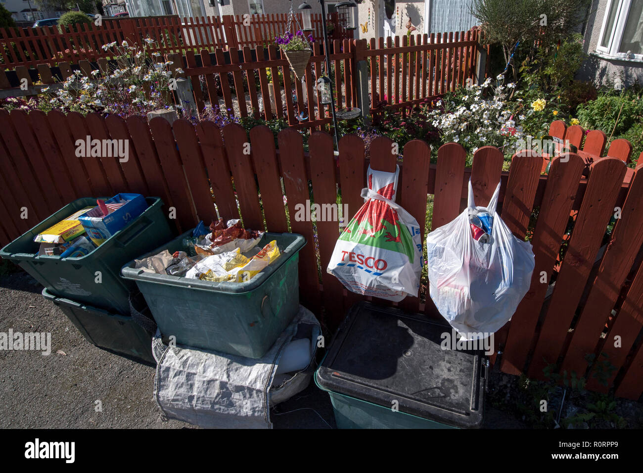 General view of recycling bins and bags of waste outside a house on a