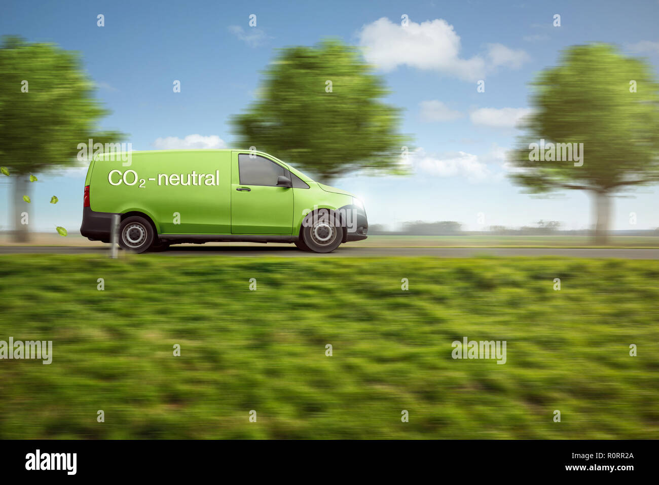Carbon-neutral delivery with a green van driving on a country road with green trees Stock Photo