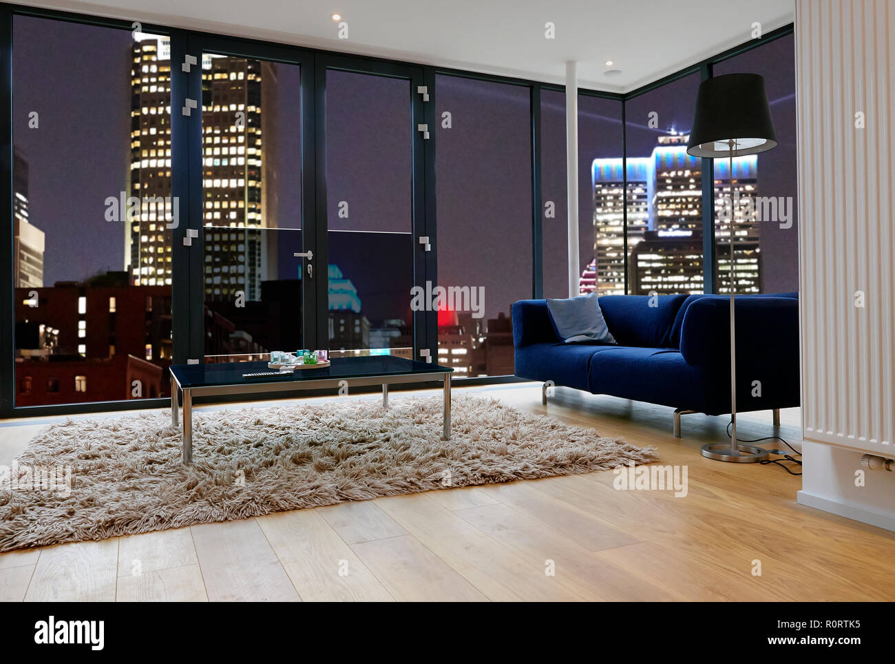 Modern living room with large windows and view on city panorama. There