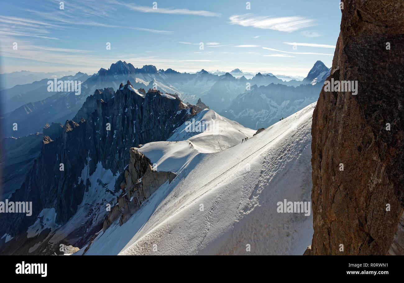 Chamonix, south-east France, Auvergne-Rhône-Alpes. Climbers heading for Mont Blanc. Descending from Aiguille du Midi cable car station towards sunny s Stock Photo