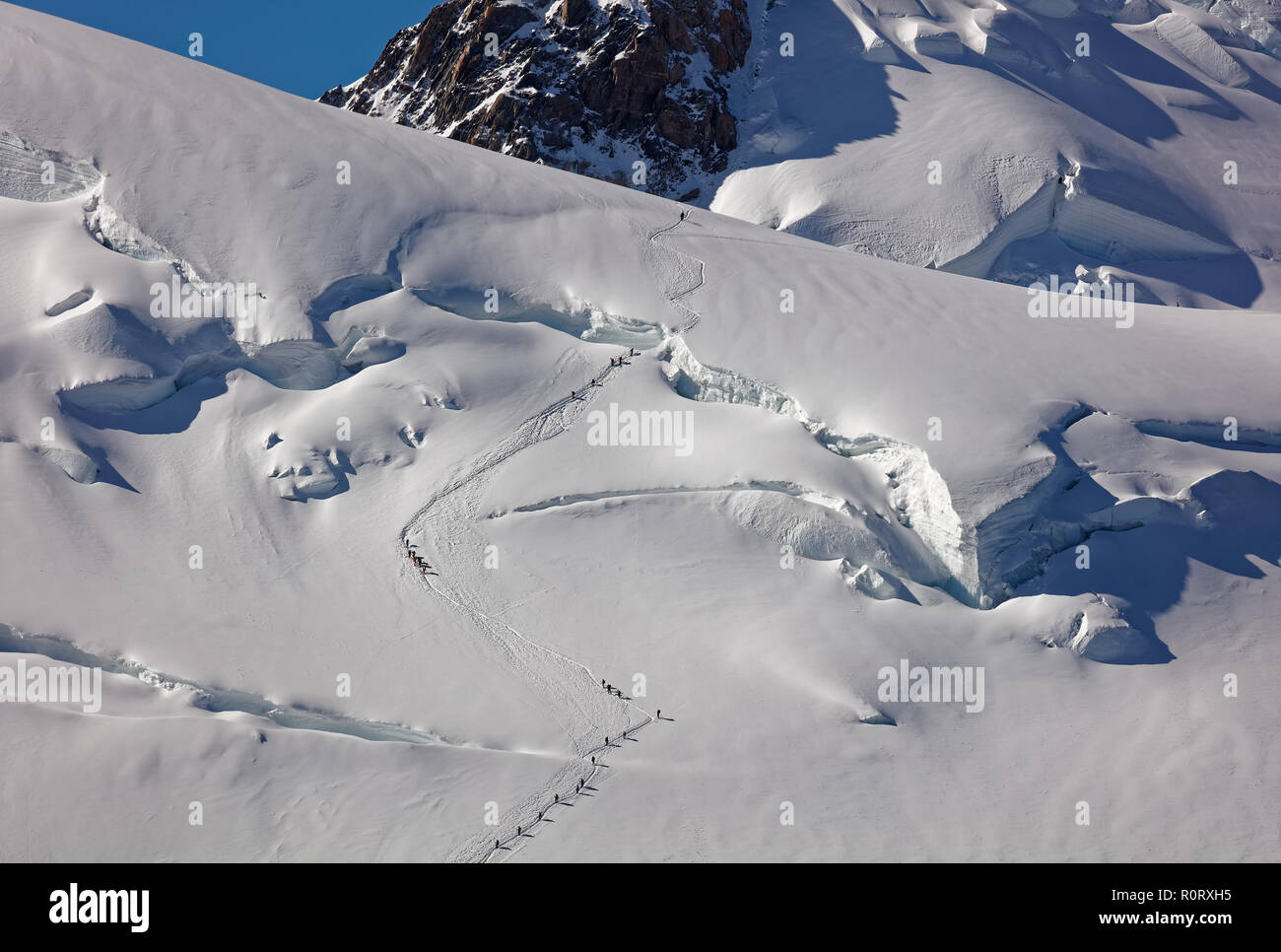 Pointe Lachenal, Chamonix, south-east France, Auvergne-Rhône-Alpes. Climbers heading for Mont Blanc - scaling Pointe Lachenal's glacier crevasse with  Stock Photo