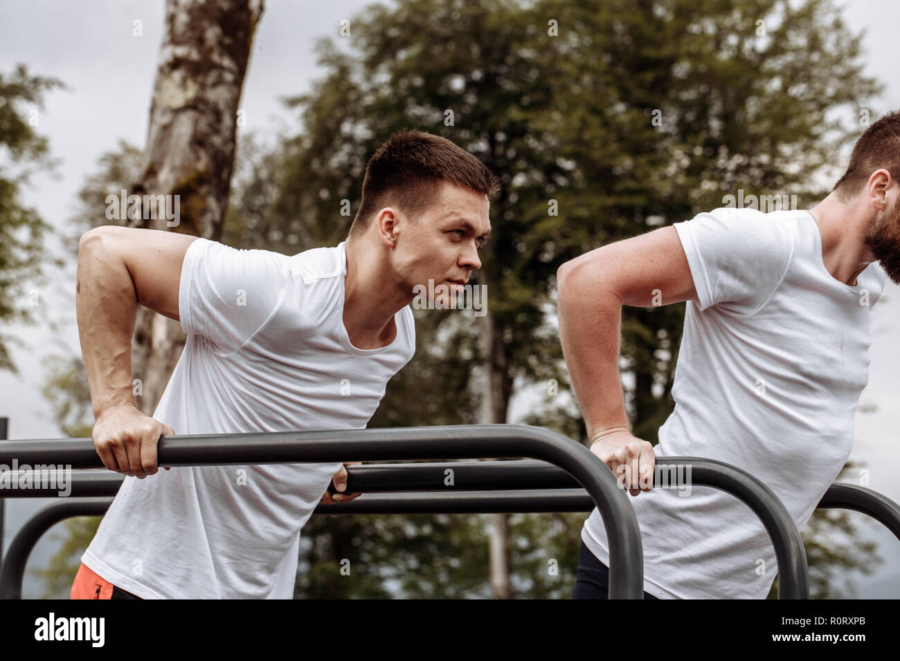 Two sportsmen doing dips on parallel bars Stock Photo Alamy