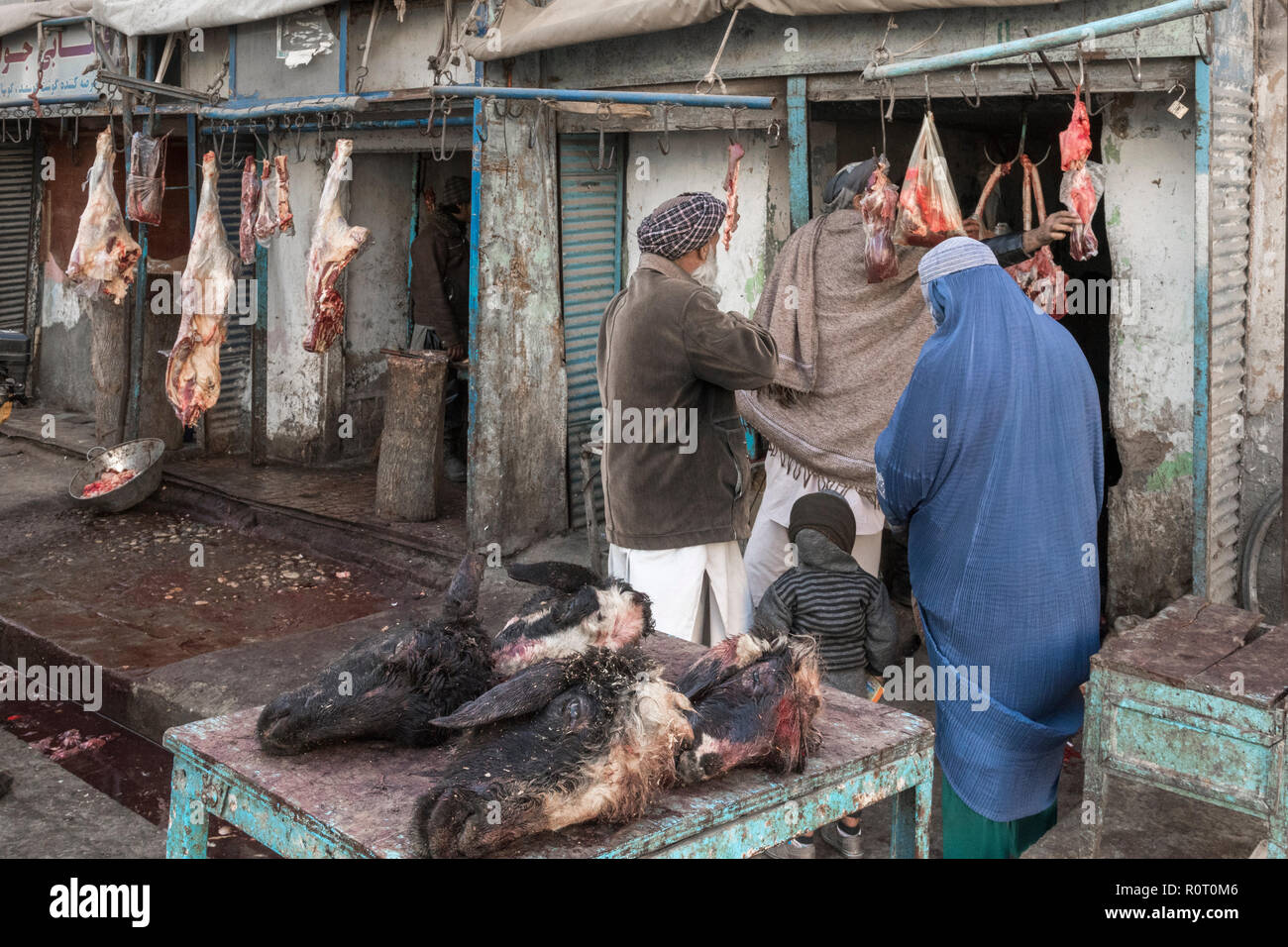 Husband And Wife Wearing Blue Burqa Buyig Meat From A Butcher At The Mazar-e Sharif Central Bazaar, Maraz-e Sharif, Balkh Province, Afghanistan Stock Photo