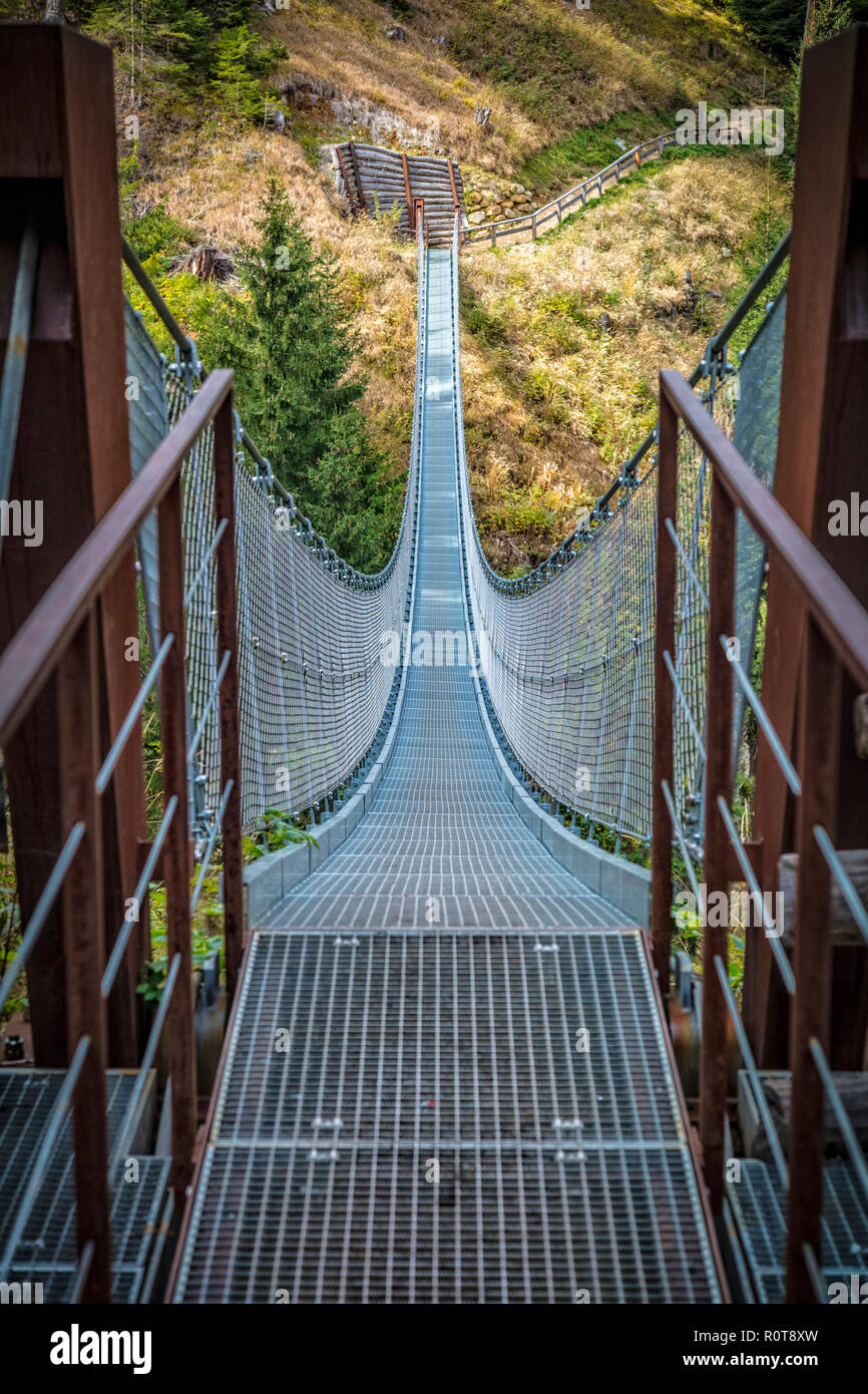 metal suspended bridge in rabby valley on dolomites Stock Photo