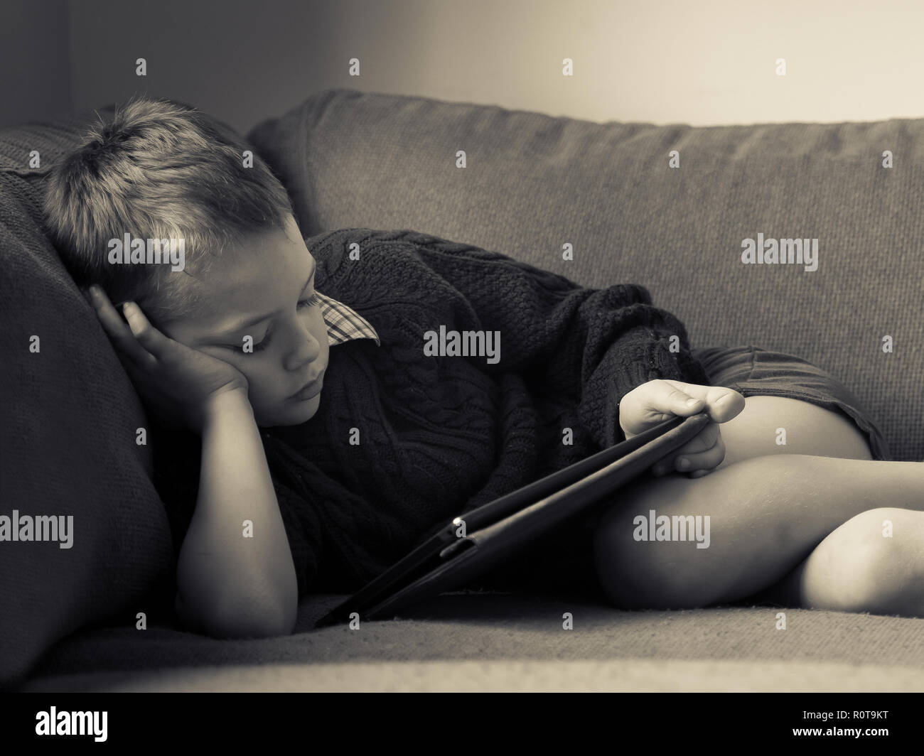 A little boy with ADHD, Autism, Asperger syndrome reading a book on the  sofa after breaking his leg and having it put in a cast at the hospital  Stock Photo - Alamy