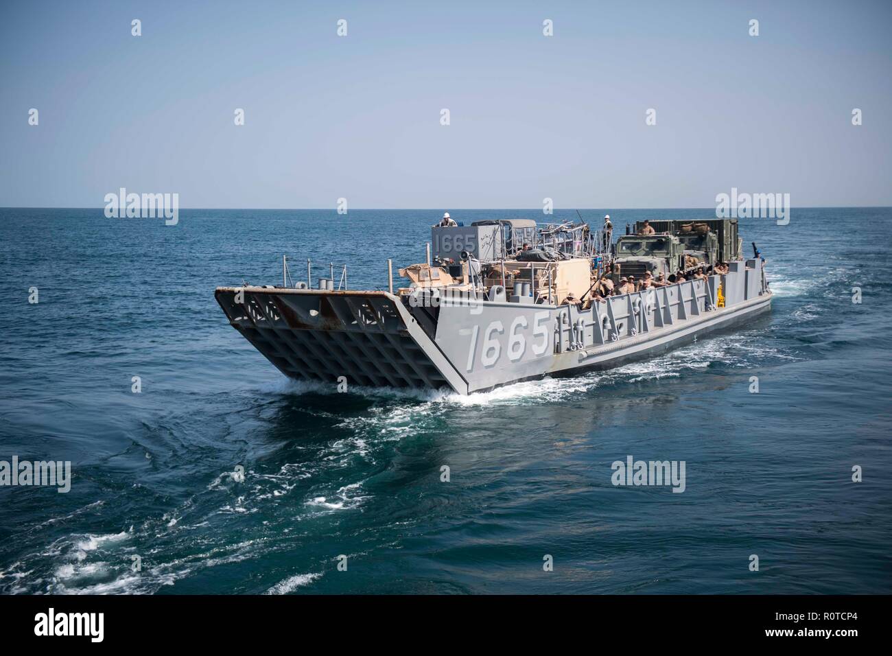 181105-N-GR847-2006 ARABIAN GULF (Nov. 5, 2018) Landing Craft Utility 1665, attached to Assault Craft Unit (ACU) 1, transits the Arabian Gulf during a regularly scheduled deployment of the Essex Amphibious Ready Group (ARG) and 13th Marine Expeditionary Unit (MEU). The Essex ARG/13th MEU is a flexible and persistent Navy-Marine Corps team deployed to the U.S. 5th Fleet area of operations in support of naval operations to ensure maritime stability and security in the Central Region, connecting to the Mediterranean and the Pacific through the western Indian Ocean and three strategic choke points Stock Photo