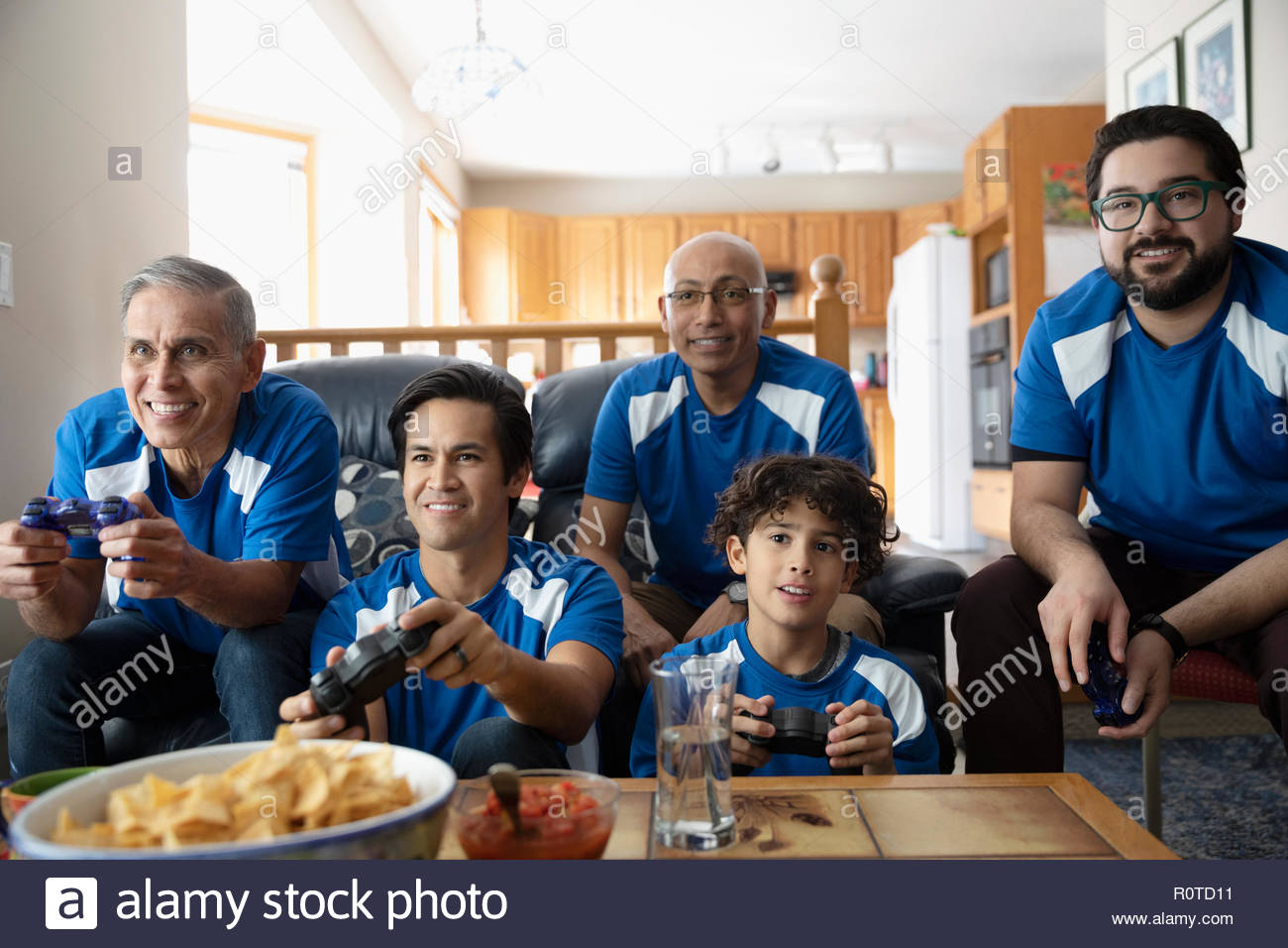 Latinx multi-generation family playing sports video game Stock Photo