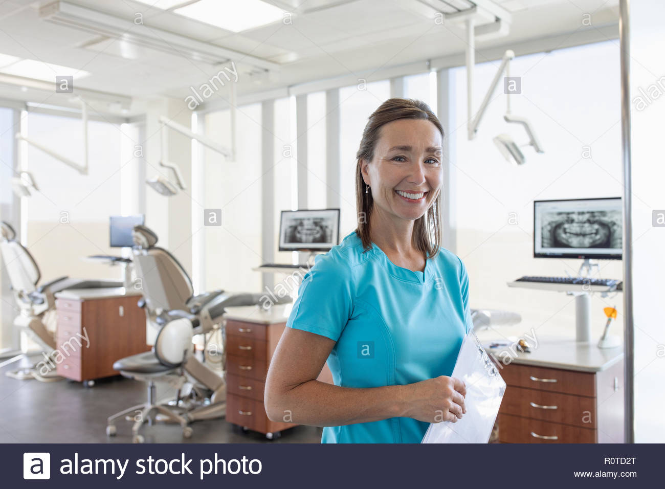 Portrait smiling, confident female dental hygienist in dentist office Stock Photo