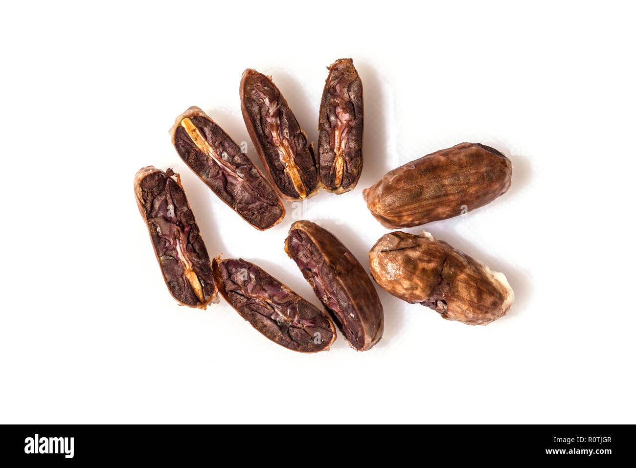 Fresh cocoa beans or cacao with half sliced and two whole beans on